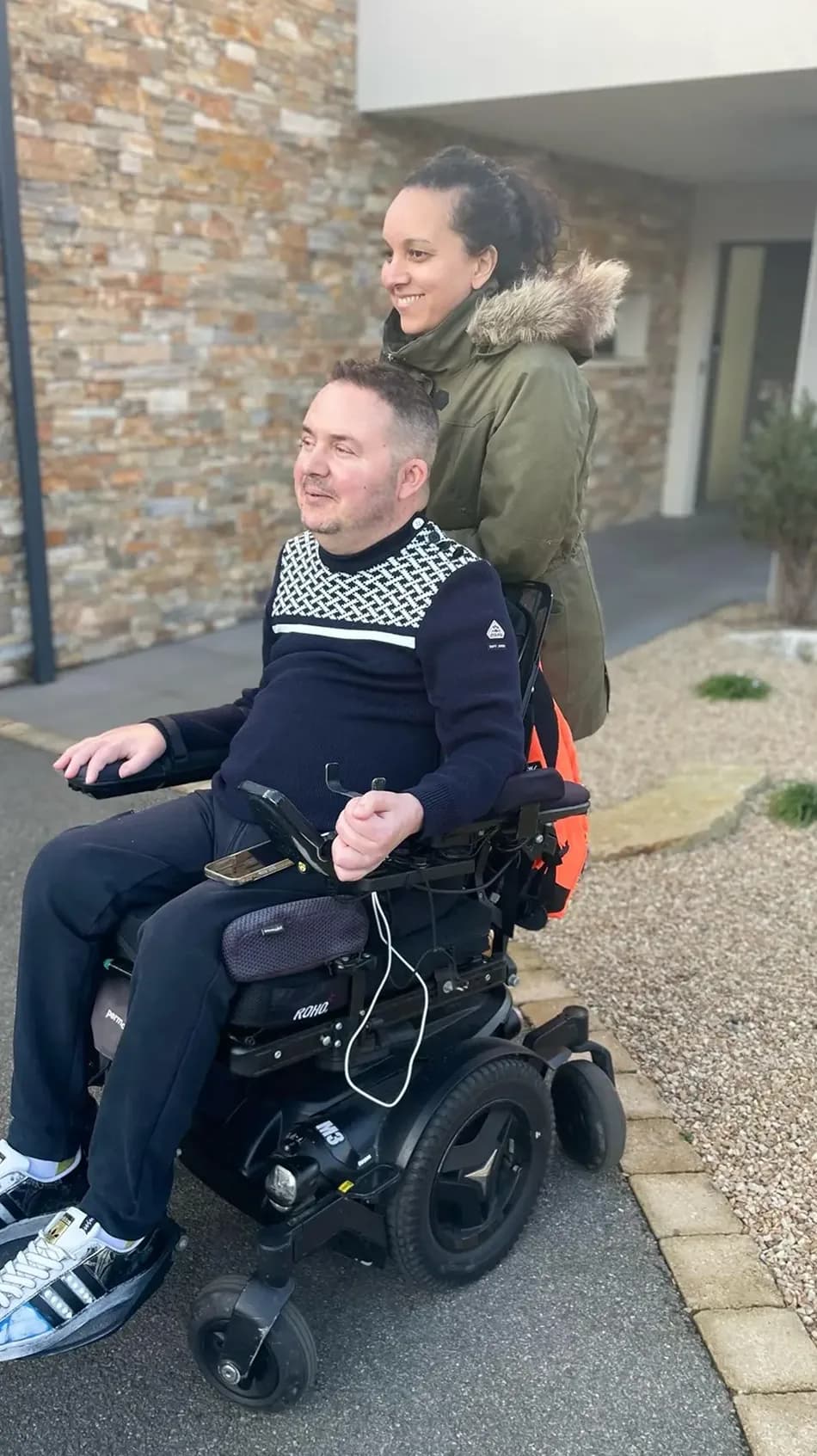 Julien, cofondateur en fauteuil roulant, devant une maison avec Naoil