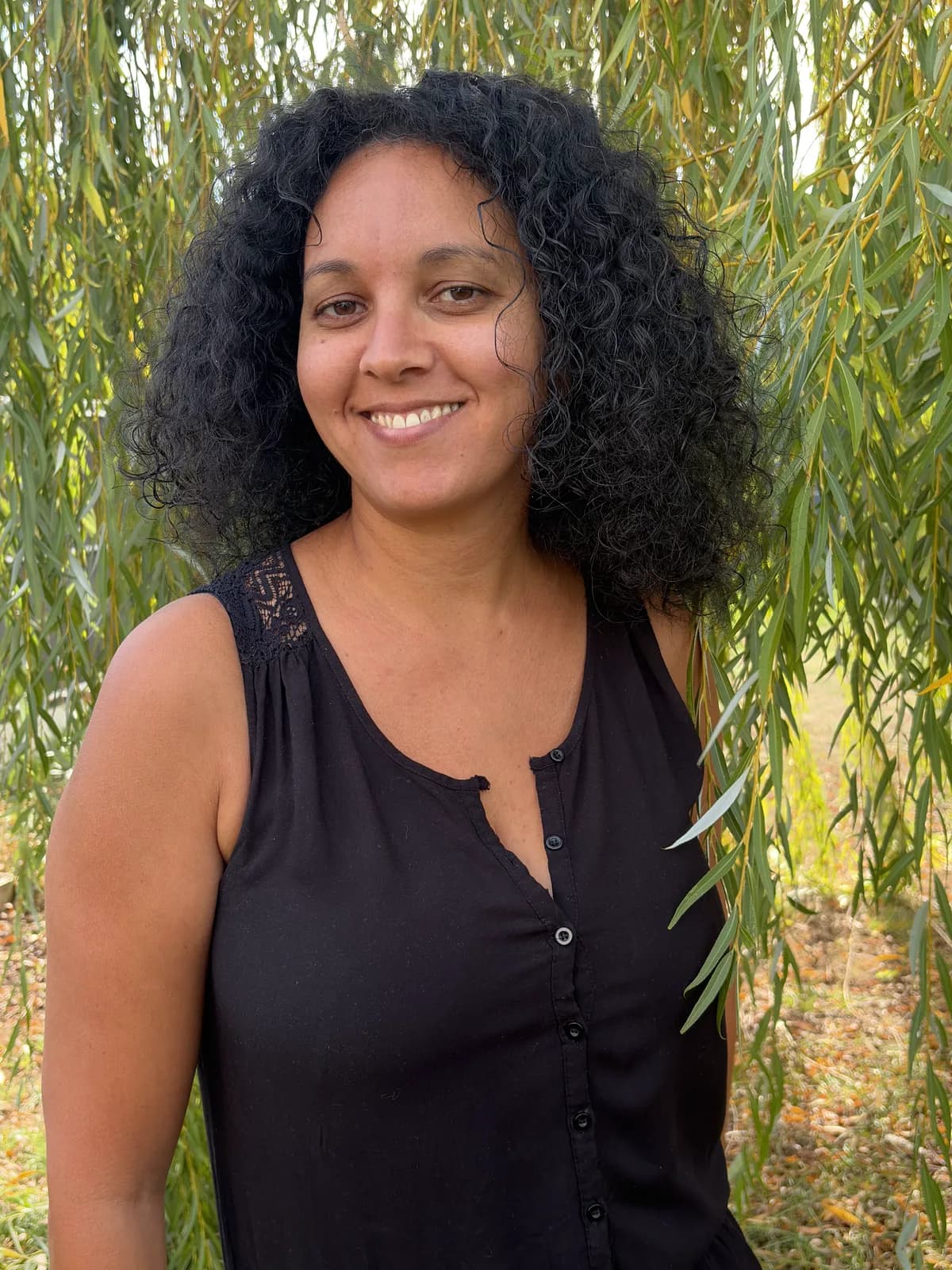 Naoil, cofondatrice et auxiliaire de vie, souriante sous un saule