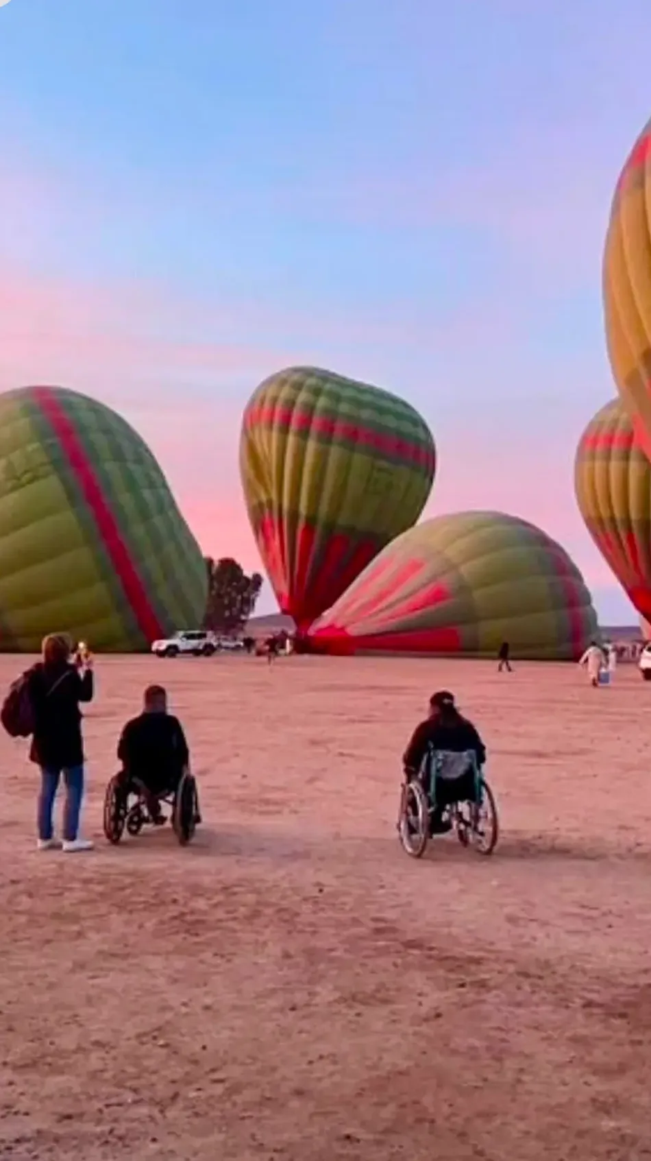 Sortie en fauteuil roulant au milieu de montgolfières au lever du soleil